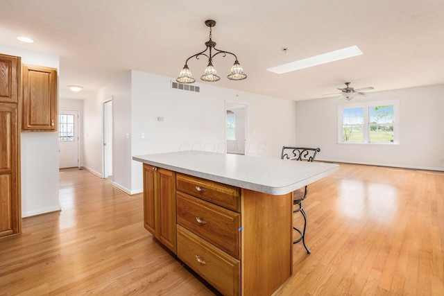 306 Northview Dr, London, OH 43140 - kitchen with a kitchen breakfast bar, visible vents, a skylight, a center island, and light wood finished floors
