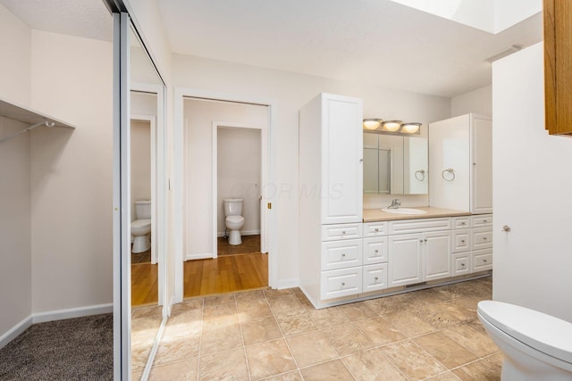 306 Northview Dr, London, OH 43140 - bathroom featuring vanity, toilet, and baseboards