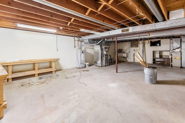 306 Northview Dr, London, OH 43140 - unfinished below grade area with heating unit, water heater, a sink, and visible vents