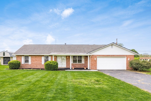 306 Northview Dr, London, OH 43140 - ranch-style house with an attached garage, brick siding, driveway, and a front lawn