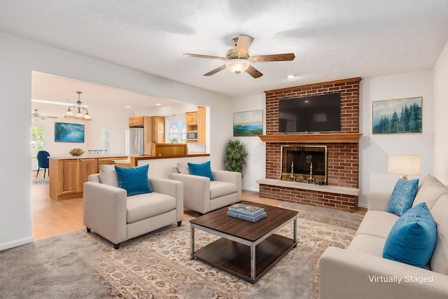 306 Northview Dr, London, OH 43140 - living area featuring baseboards, ceiling fan with notable chandelier, and a brick fireplace