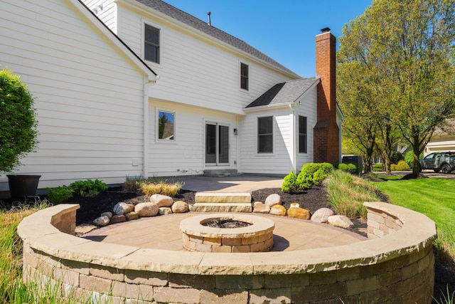 back of property with an outdoor fire pit and a patio area