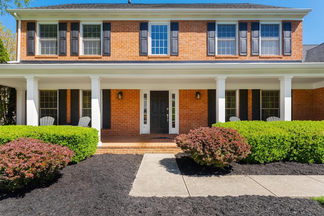 view of front of property with a porch and brick siding