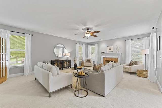 living area with baseboards, a ceiling fan, and plenty of natural light