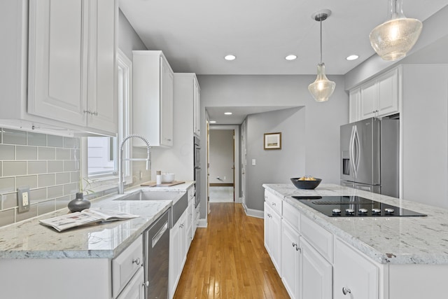 kitchen with a kitchen island, stainless steel appliances, white cabinets, and a sink