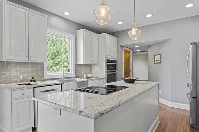 kitchen with white cabinets, stainless steel appliances, baseboards, and a sink