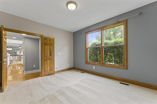 unfurnished bedroom with baseboards, visible vents, and carpet