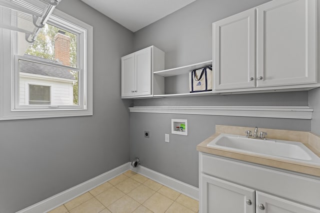 laundry room with baseboards, light tile patterned floors, hookup for a washing machine, a sink, and electric dryer hookup