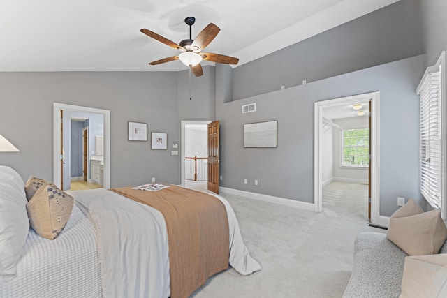 bedroom featuring high vaulted ceiling, ensuite bathroom, visible vents, baseboards, and light carpet