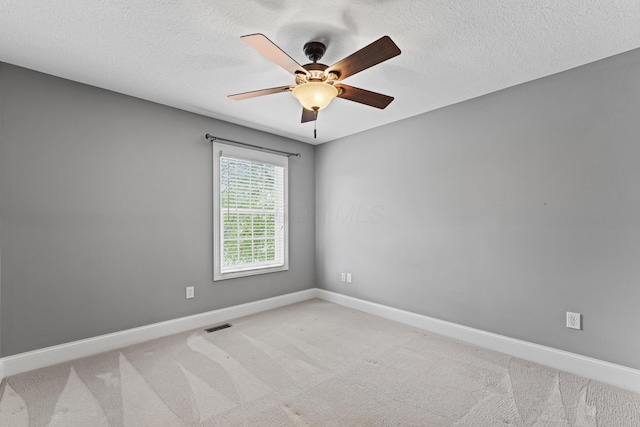 empty room with ceiling fan, a textured ceiling, baseboards, and carpet floors