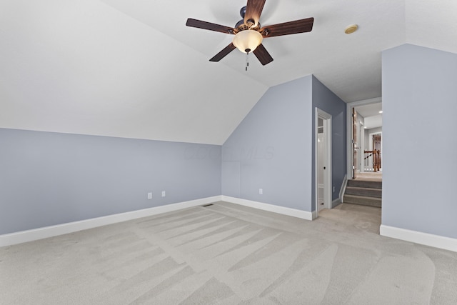 bonus room featuring lofted ceiling, baseboards, ceiling fan, and light colored carpet