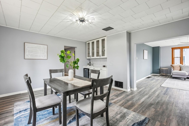 dining room with dark wood finished floors, baseboards, and visible vents