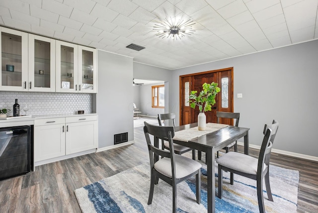 dining room with baseboards, visible vents, beverage cooler, and dark wood-style flooring