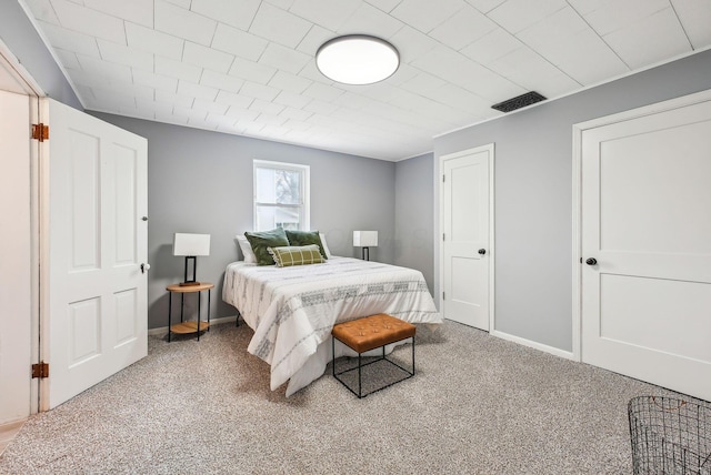 carpeted bedroom featuring baseboards and visible vents
