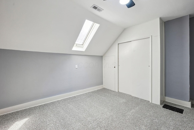 bonus room with baseboards, visible vents, carpet, and vaulted ceiling with skylight