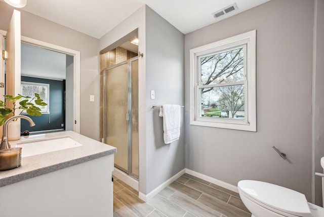 full bath with a shower stall, baseboards, visible vents, and toilet