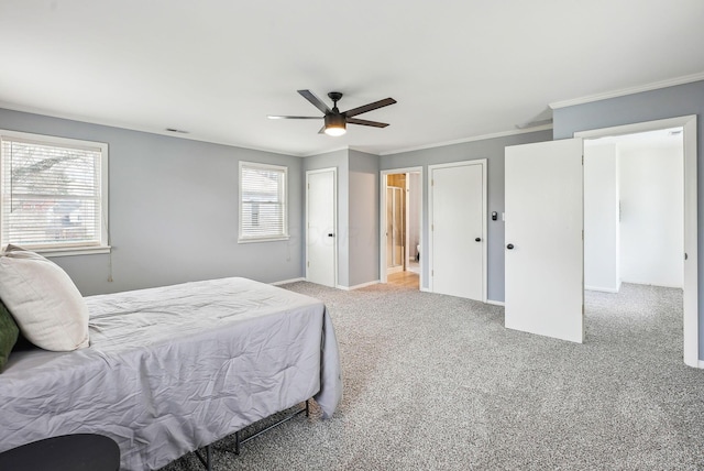 carpeted bedroom with baseboards, visible vents, ceiling fan, and ornamental molding