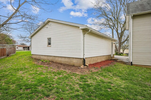 view of side of home with a yard
