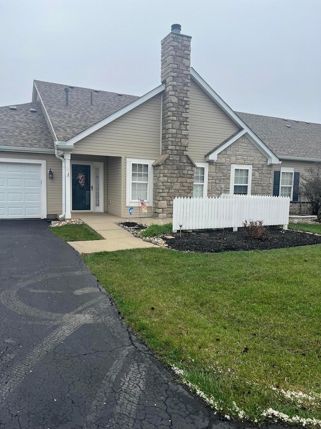 view of front of house with fence, roof with shingles, a front lawn, a garage, and a chimney