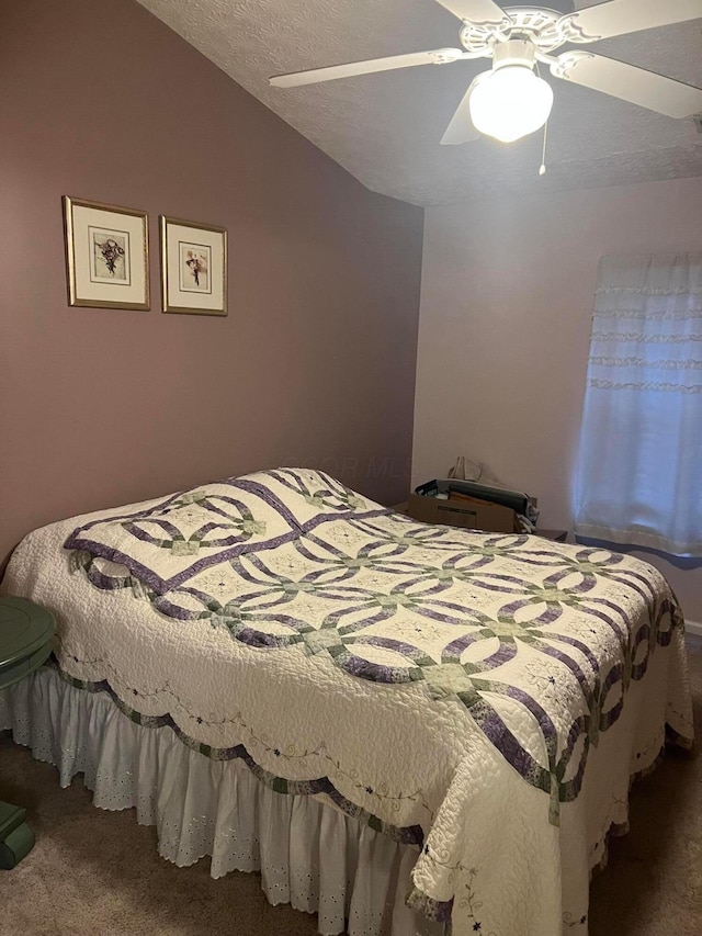 carpeted bedroom featuring a ceiling fan, vaulted ceiling, and a textured ceiling