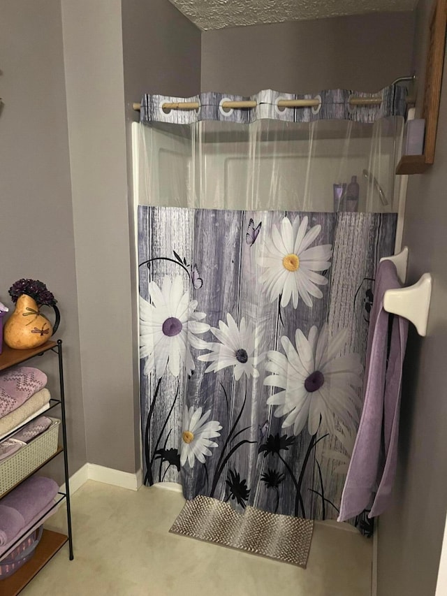 full bathroom with baseboards and a shower with shower curtain