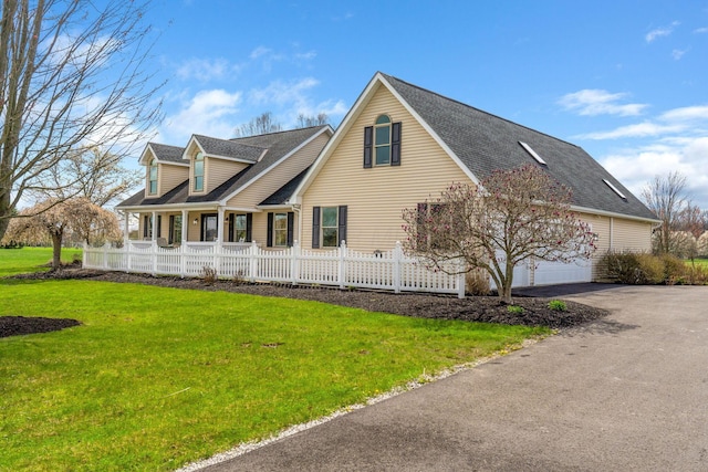 view of property exterior featuring aphalt driveway, covered porch, a lawn, fence, and a shingled roof