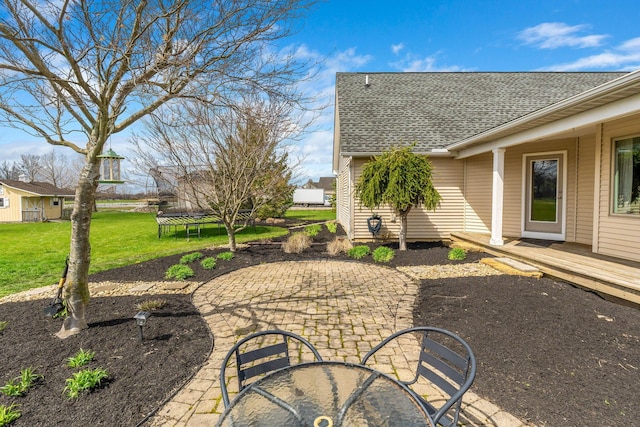 view of yard featuring a patio area, a trampoline, and a wooden deck