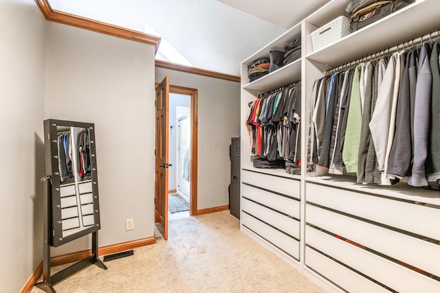 spacious closet with light carpet, vaulted ceiling, and visible vents