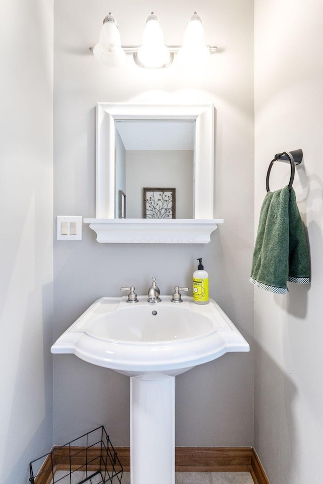 bathroom featuring a sink and baseboards