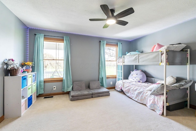 bedroom with carpet floors, baseboards, a ceiling fan, and visible vents