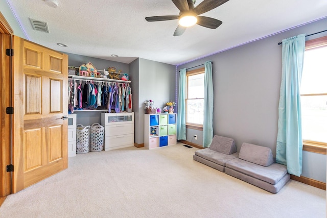 interior space featuring carpet flooring, visible vents, and a ceiling fan