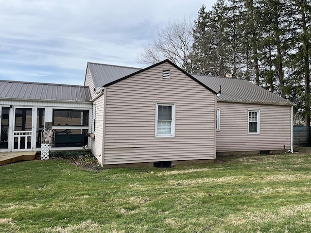 view of side of property with a yard, metal roof, and a sunroom
