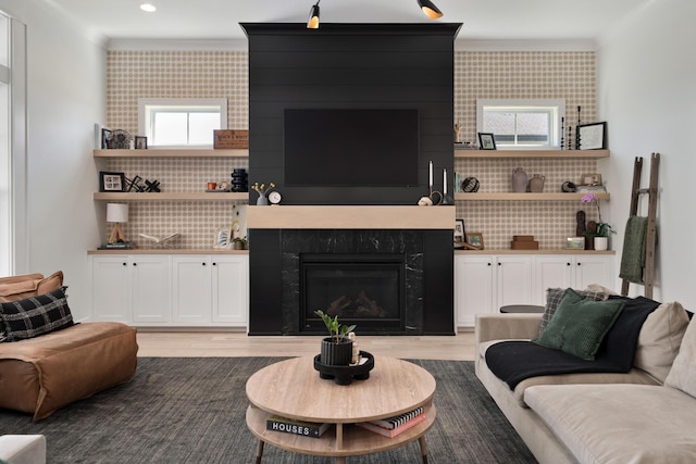 living area with a fireplace, light wood-type flooring, ornamental molding, recessed lighting, and wallpapered walls