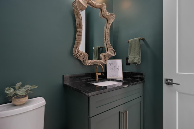 half bathroom featuring vanity and toilet