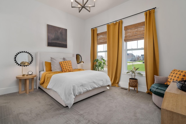 bedroom featuring baseboards, a notable chandelier, and carpet