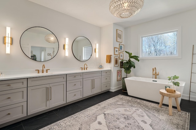 bathroom with double vanity, baseboards, a sink, and a soaking tub