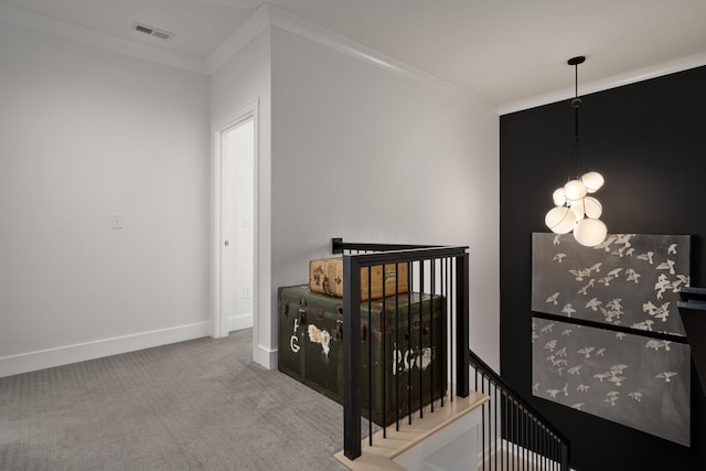 interior space featuring baseboards, ornamental molding, an upstairs landing, visible vents, and carpet