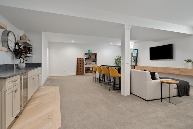 living area featuring recessed lighting, light colored carpet, indoor bar, and wine cooler