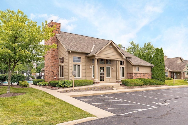 1397 Underwood Farms Blvd, Columbus, OH 43230 - view of front facade featuring a chimney, a shingled roof, uncovered parking, brick siding, and a front yard