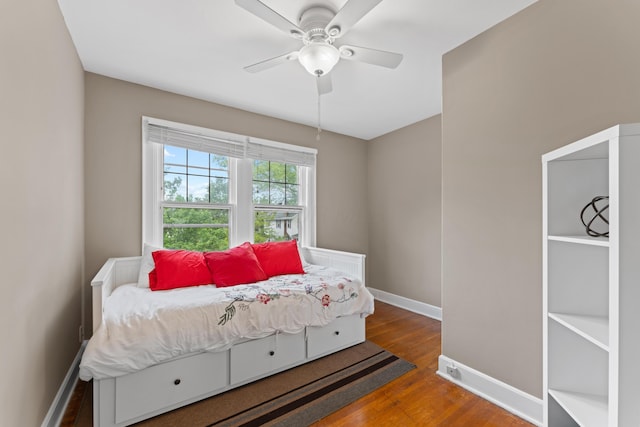 bedroom featuring wood finished floors, baseboards, and a ceiling fan