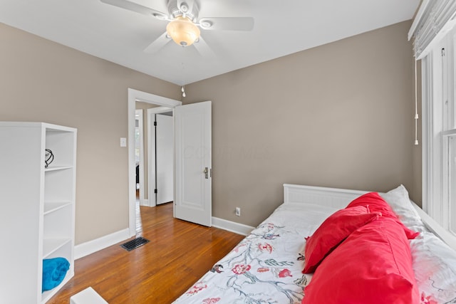 bedroom with wood finished floors, baseboards, and a ceiling fan