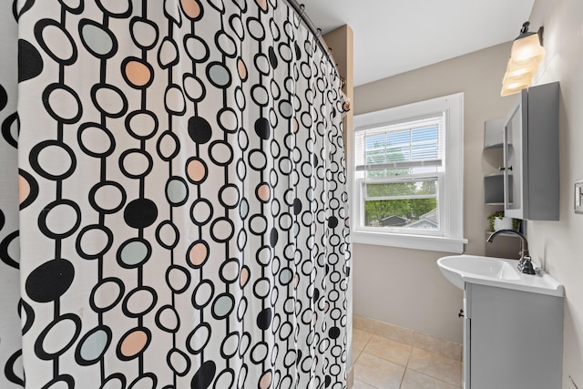 full bathroom featuring tile patterned floors, baseboards, vanity, and a shower
