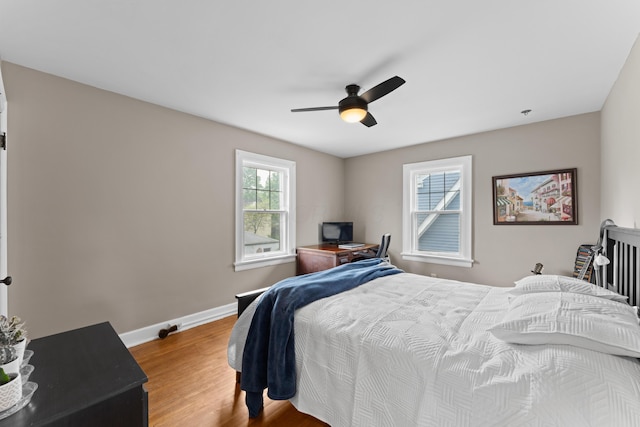 bedroom featuring wood finished floors, baseboards, and a ceiling fan