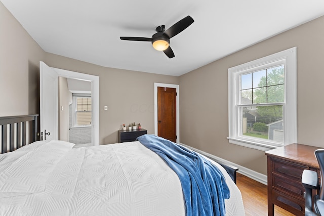 bedroom with wood finished floors, baseboards, and ceiling fan