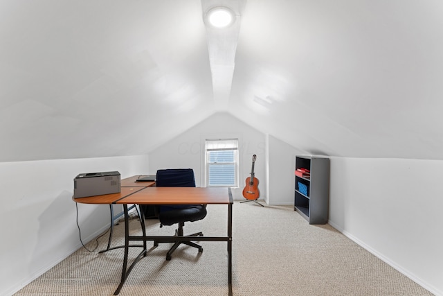 carpeted office space with lofted ceiling and baseboards