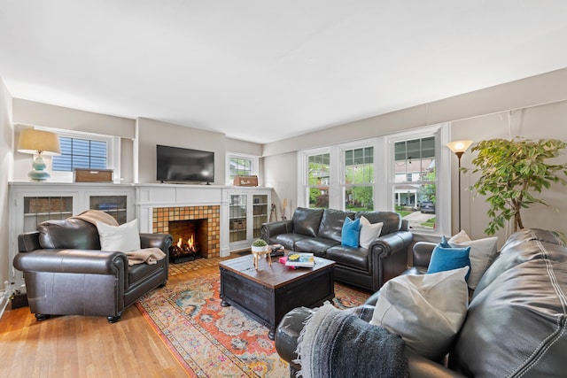 living area with a tile fireplace and light wood-style floors