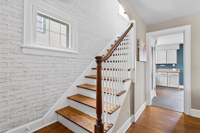 stairway featuring wood finished floors and baseboards