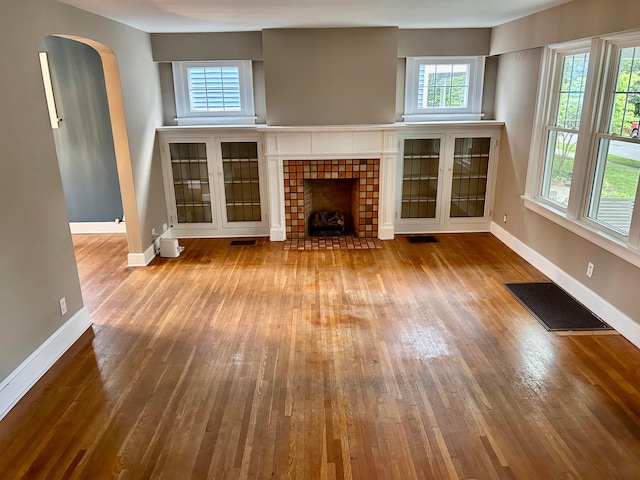 742 S Cassingham Rd, Bexley, OH 43209 - unfurnished living room with wood-type flooring, plenty of natural light, and a tiled fireplace