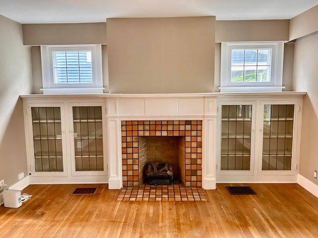 742 S Cassingham Rd, Bexley, OH 43209 - unfurnished living room with wood finished floors, a tile fireplace, and healthy amount of natural light
