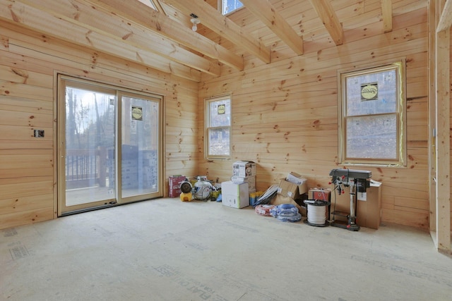 interior space featuring wood walls and beam ceiling